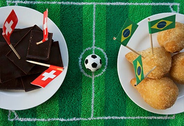 Cancha fútbol con banderas países. Comidas para Juegos Olímpicos