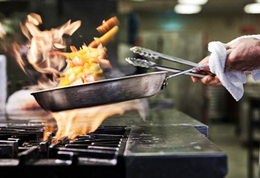 Chef utilizando pinzas de cocina multiusos al cocinar 