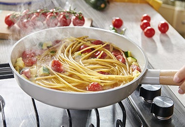 Confitar tomates en una sartén en receta de pasta