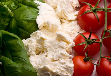 Ingredientes frescos para preparar una salsa italiana: rúgula, queso y tomates.