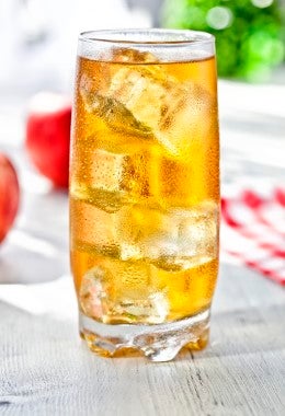 Refrescante jugo de manzana con hielo para tomar junto a un aperitivo de queso provolone.