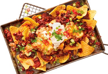 Deliciosa bandeja rellena de nachos de pulled pork en toma cenital