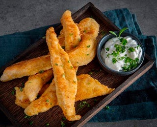 Palitos de pollo amontonados con un dip, una exquisita variante de los palitos de queso