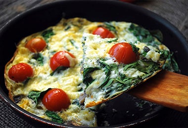 Una porción de frittata italiana con huevo, hierbas y tomates cherry