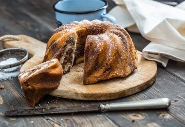 Bundt cake espolvoreado con azúcar glas, acompañado de tamiz de malla fina