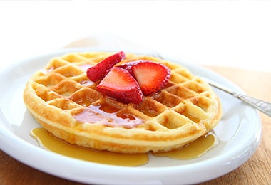 Waffles con miel y frutillas al desayuno