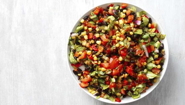 Una ensalada cremosa con maíz, tomate y palta en toma cenital