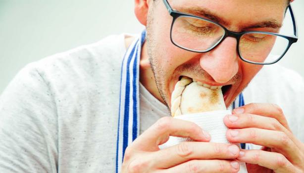 Hombre degustando unas deliciosas empanadas de hojaldre